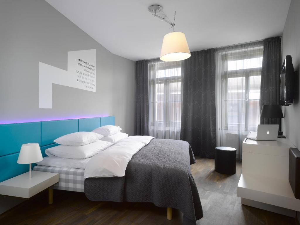 a hotel room with a bed, chair, lamp and a window at MOODs boutique hotel in Prague