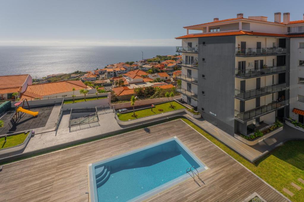 Una vista aérea de un edificio con piscina. en FLH Garajau Fantastic Ocean View with Balcony, en Funchal