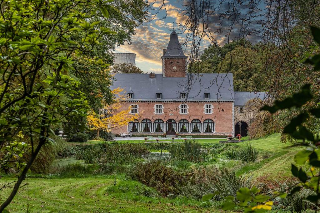 ein großes Backsteingebäude mit einem Turm darüber in der Unterkunft Château de Bonne Espérance in Huy