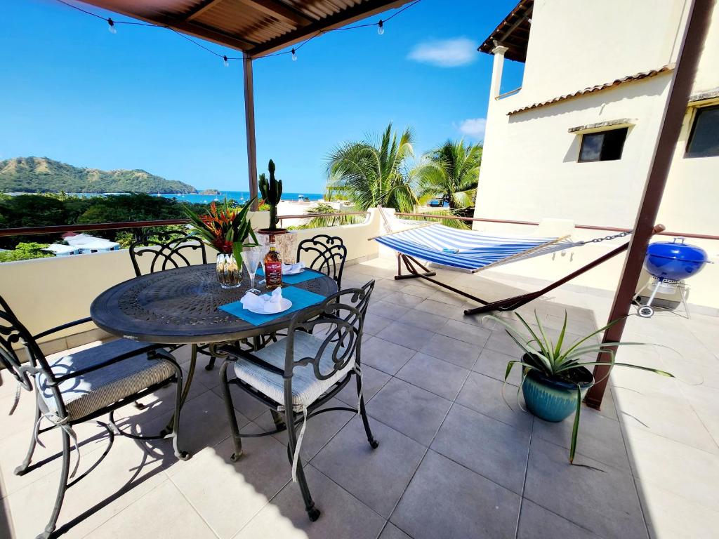 patio con mesa y sillas en el balcón en Amazing Oceanview rooftop terrace walk to beach, en Coco