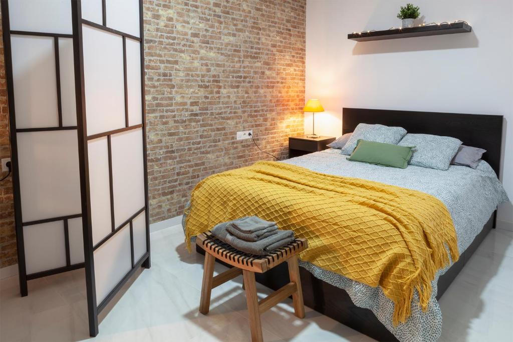 a bedroom with a bed and a brick wall at Artistic Digital Retreat-Great Location Near Metro in Valencia