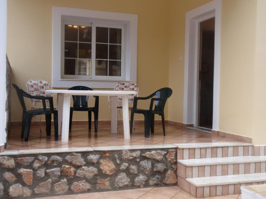 einen Tisch und Stühle auf einer Veranda mit einem Fenster in der Unterkunft Traditional city house in Kalymnos