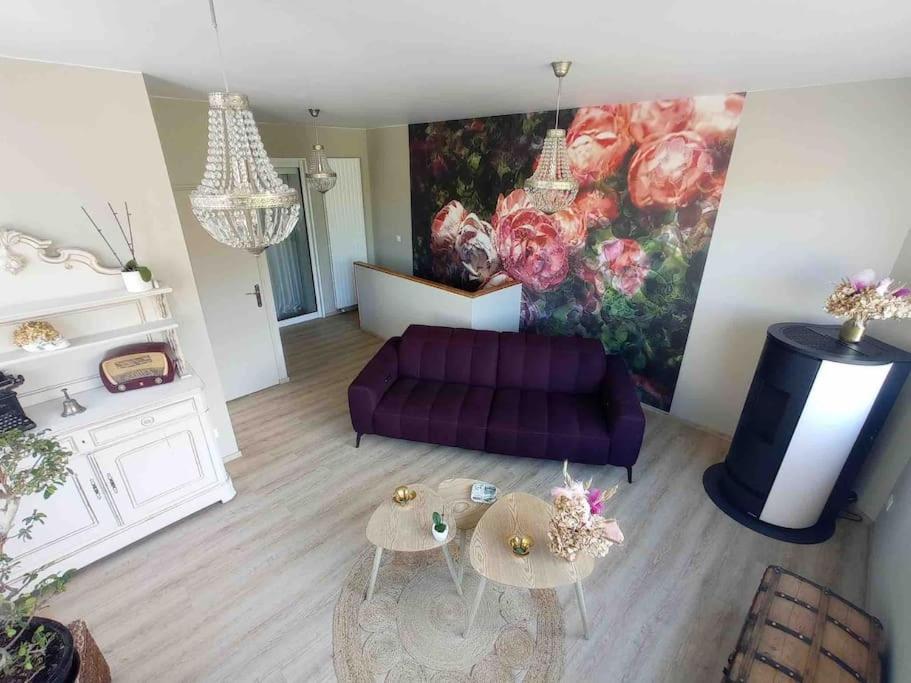 a living room with a purple couch and a painting at Appart proche centre- gare-stade-hôpital- Prisme-Belle vue in Aurillac
