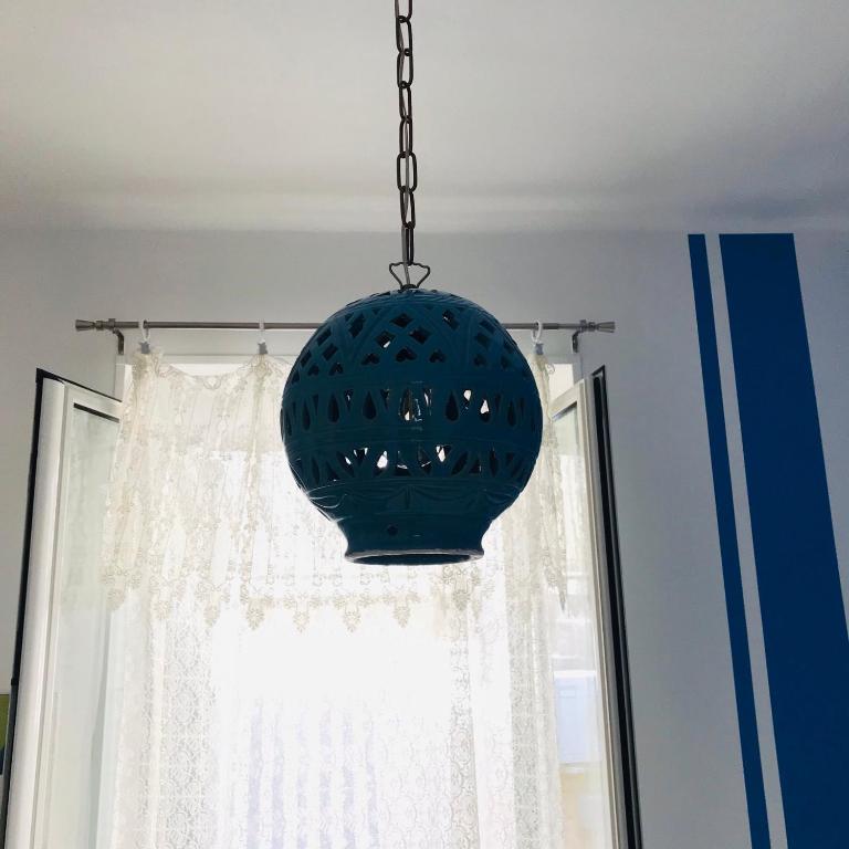 aendant light hanging from a ceiling with a window at B&B Via dell'Azzurra in Bari