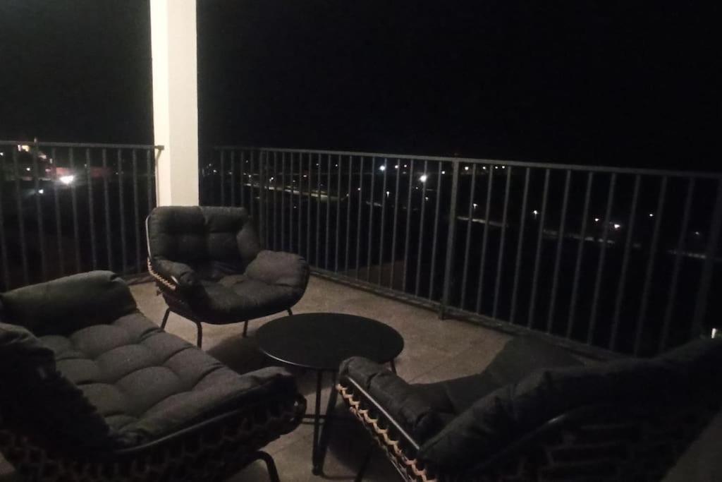 a balcony at night with two chairs and a table at KLIF 4 panorama Warki in Warka