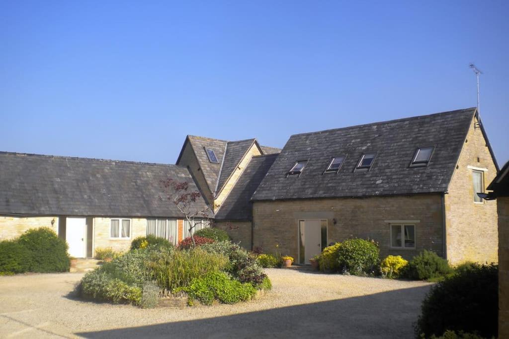 an old stone house with windows and a driveway at Broadway House, 7 Bedroom, 6 Baths in Cheltenham