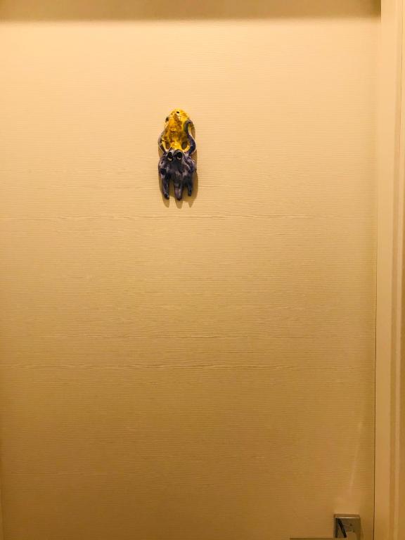 a yellow door with a ring on it at B&B Via dell'Azzurra in Bari