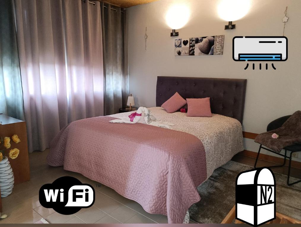 1 dormitorio con 1 cama rosa y TV en la pared en NATURE e SPA AL - Termas Saúde e Beleza, Totalmente Renovado - Piscinas Municipais em frente - Epoca Julho a Setembro en São Pedro do Sul