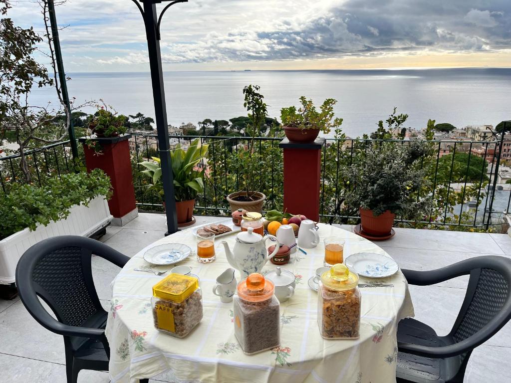 uma mesa com comida numa varanda com vista para o oceano em SALOTTO SUL MARE em Génova