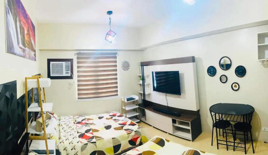 a living room with a bed and a television at 2313 Sun Vida Tower in Cebu City