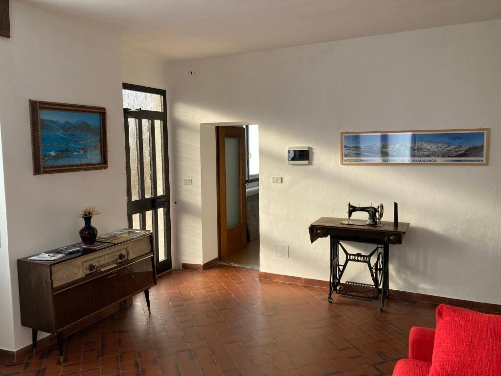 sala de estar con mesa de madera y escritorio en Casa vacanze Fregè en Castione Andevenno