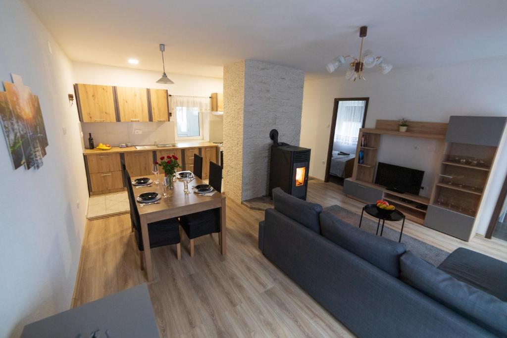 Il comprend un salon et une cuisine avec un canapé et une table. dans l'établissement Apartman Mihelčić, à Delnice