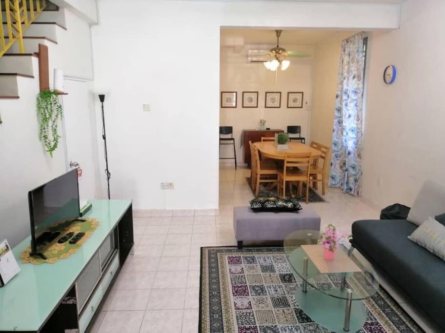 uma sala de estar com um sofá e uma mesa em Cozy house with free wifi and parking near Utm, Legoland em Skudai