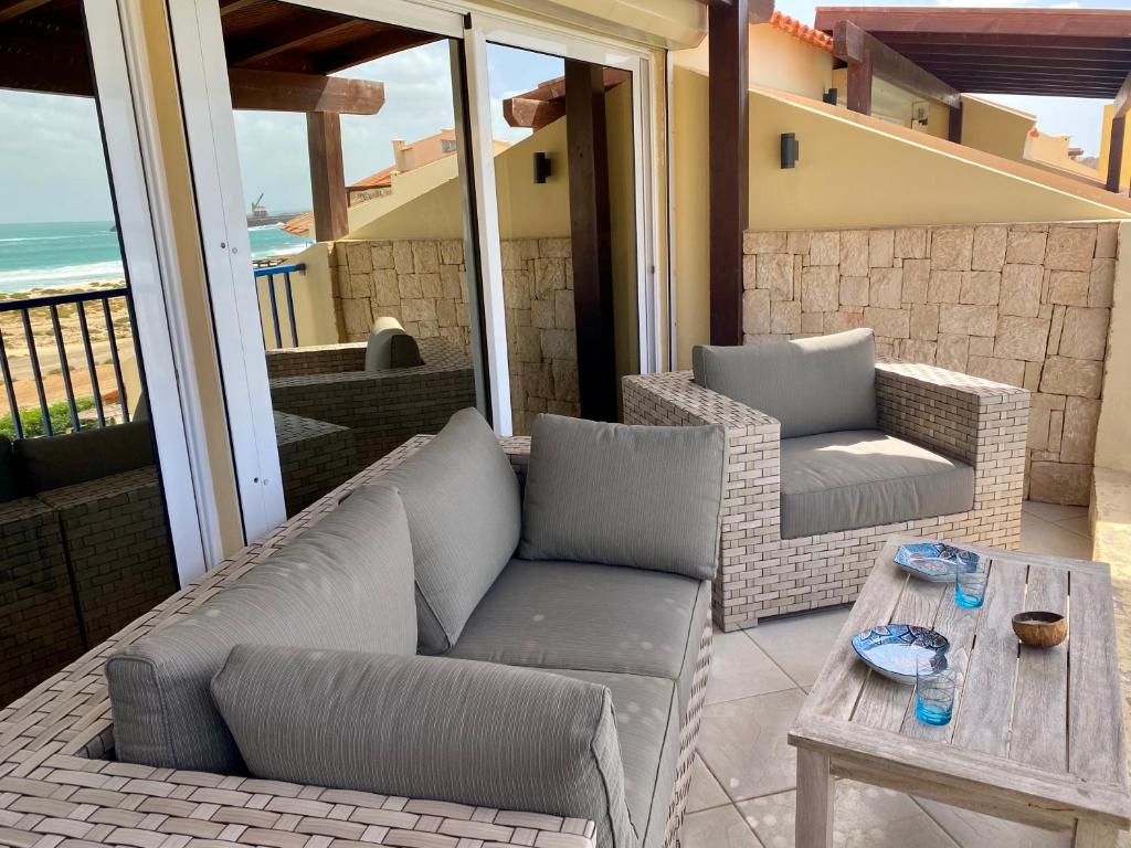 a patio with a couch and a table on a balcony at Seaview Luxury Penthouse Mare in Sal Rei