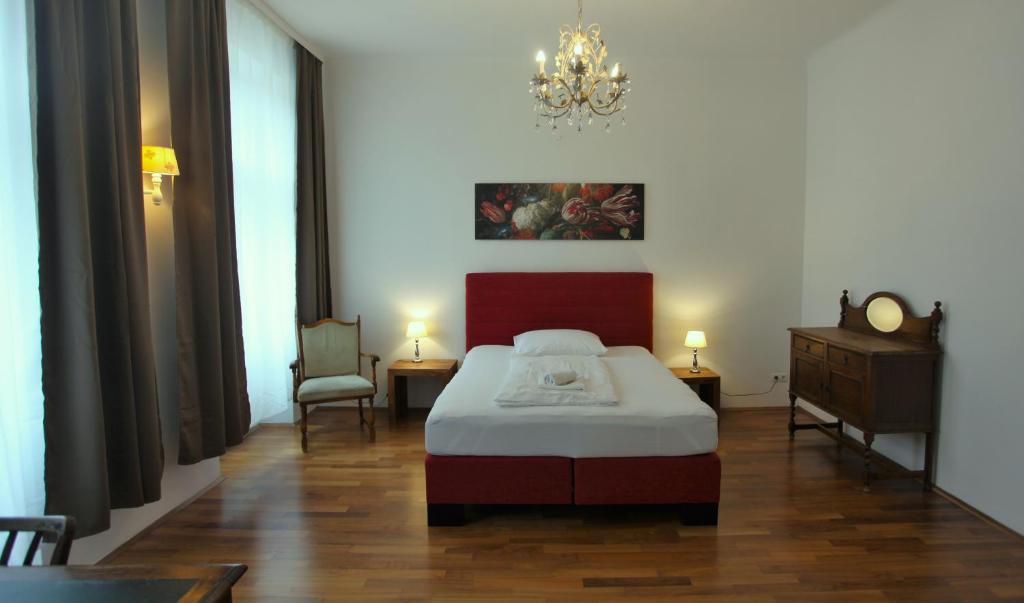 a bedroom with a bed and a chandelier at Casa Nostra - Ausgefallene Wohnung am Augarten in Vienna