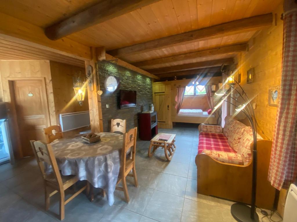 a dining room with a table and a couch at Chalet d' Annelise in Gérardmer