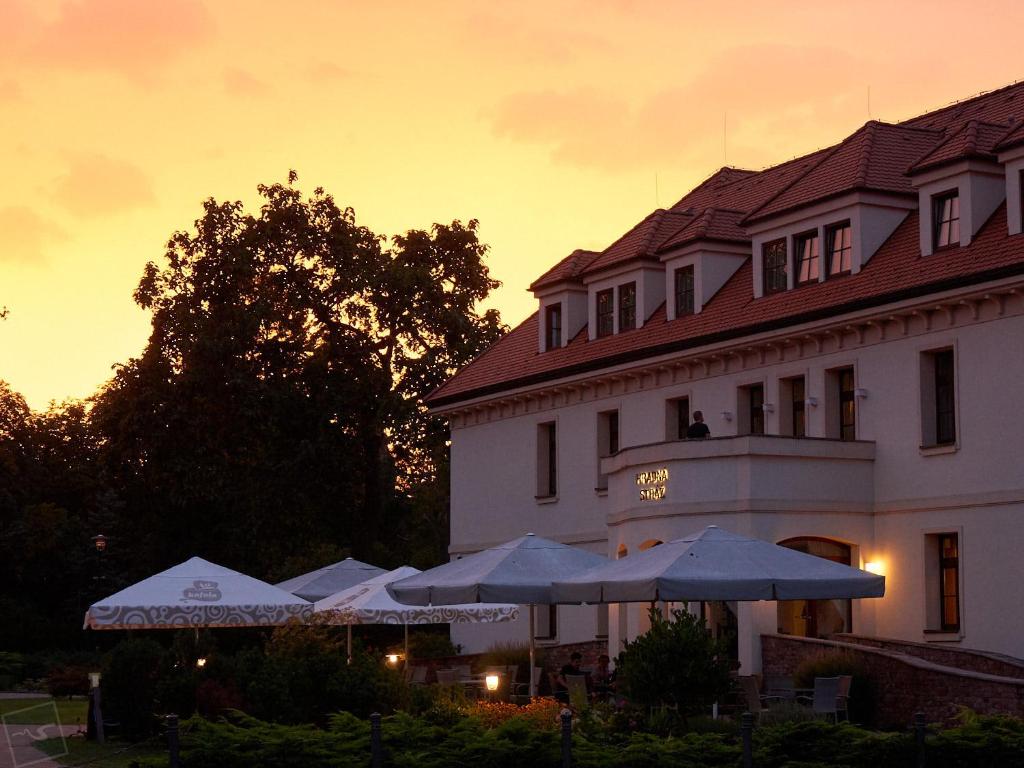 un edificio con sombrillas frente a un edificio en Hradná stráž Hotel&Apartments s privátnym wellness en Topoľčianky