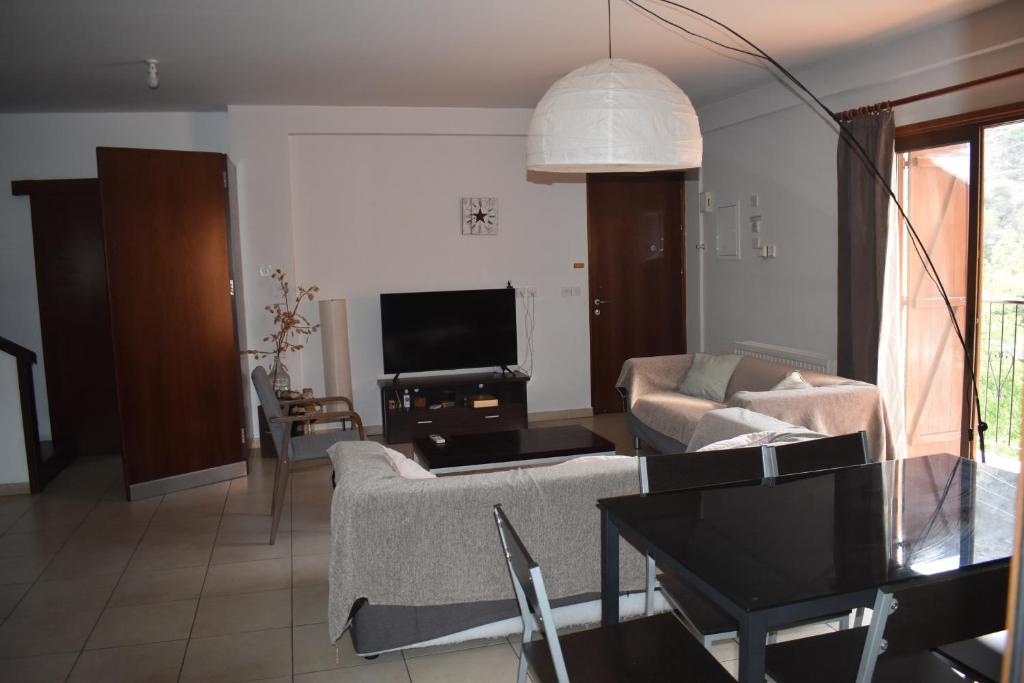 - un salon avec un canapé et une télévision dans l'établissement Moutoullas Apartment, à Nicosie