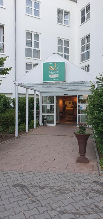 a building with a white canopy in front of it at Quality Hotel Erlangen Garni in Erlangen