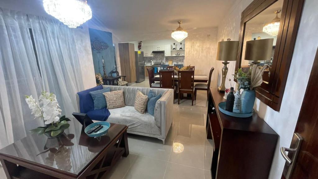 uma sala de estar com um sofá e uma mesa em Apartamento Moderno y Confortable con piscina em Santiago de los Caballeros
