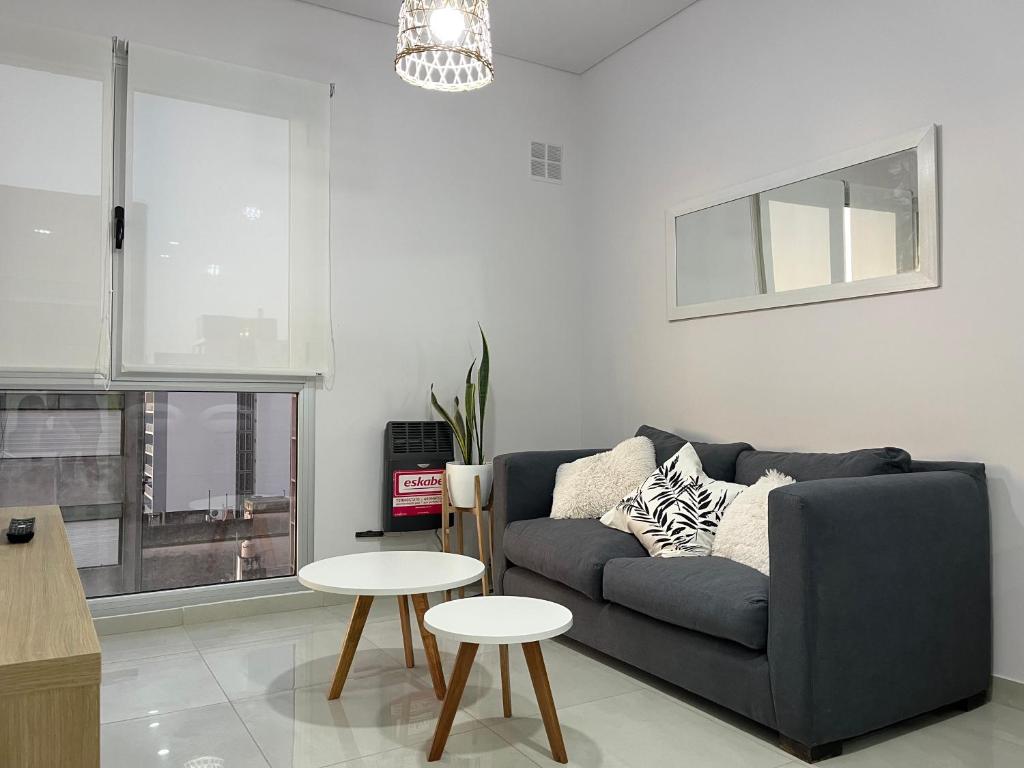 a living room with a blue couch and two tables at DEPARTAMENTO CENTRICO in Bahía Blanca