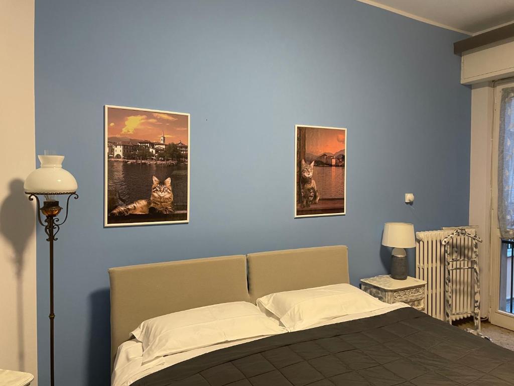 a bedroom with a bed with three pictures on the wall at B&B Gloria Apartment in Baveno