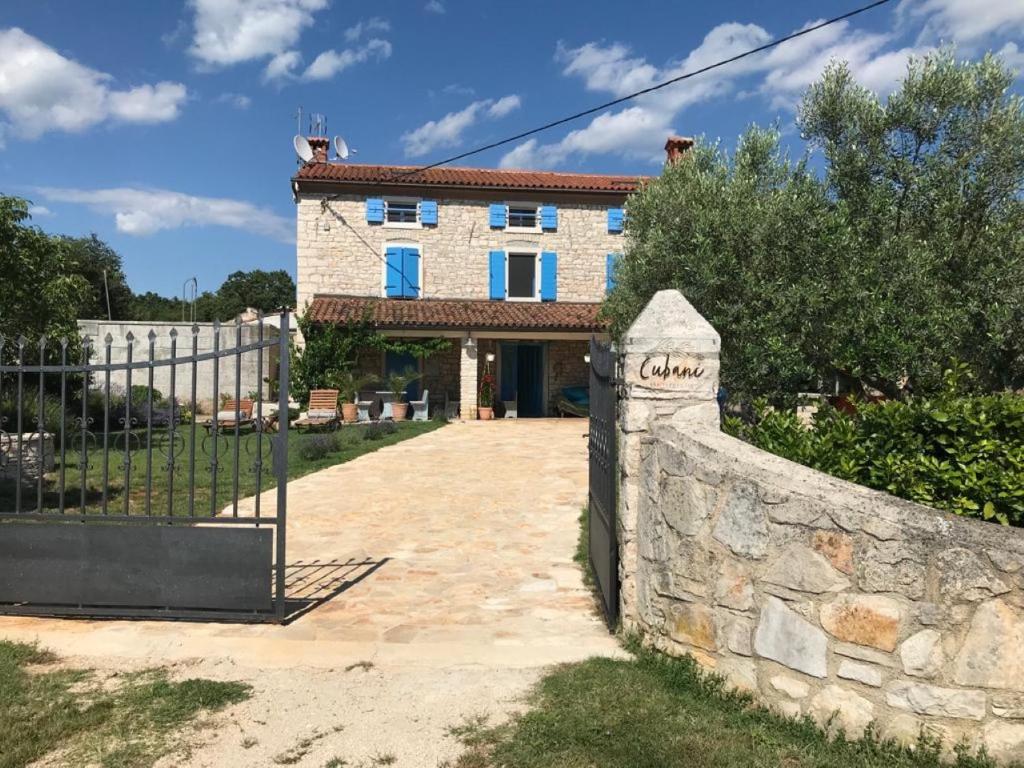 uma cerca de pedra em frente a um edifício em Farmhouse Cubani em Bale