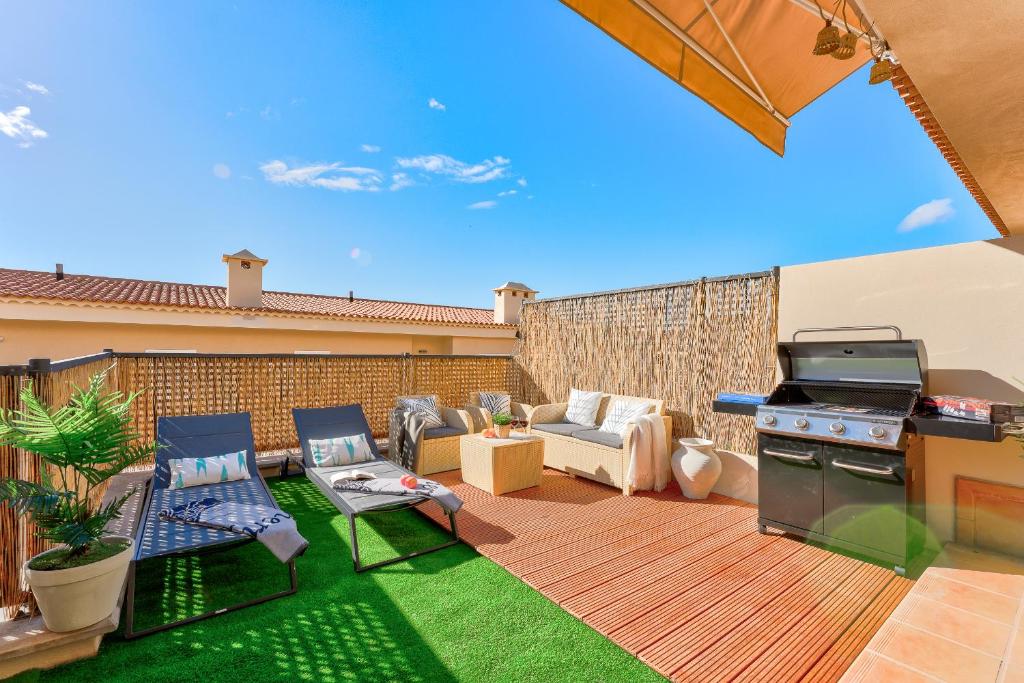 podwórko z patio z grillem i meblami w obiekcie Black Beach Luxury Vacation House w mieście Puerto de Santiago