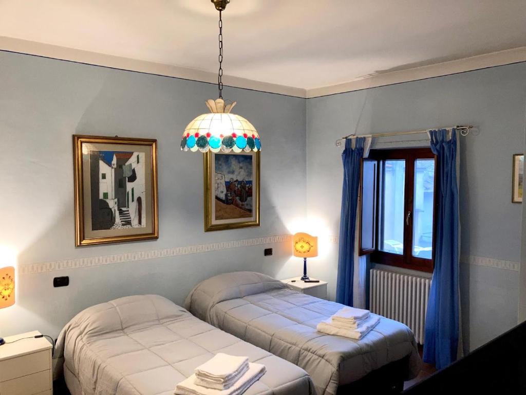 1 dormitorio con 2 camas y lámpara de araña en Borgo di Piero, en Sansepolcro