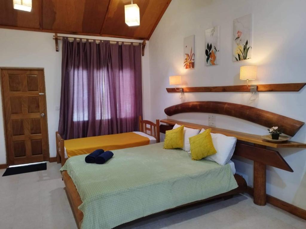 1 dormitorio con 2 camas y puerta con ventana en Reethi Villa Vaavu Thinadhoo en Thinadhoo