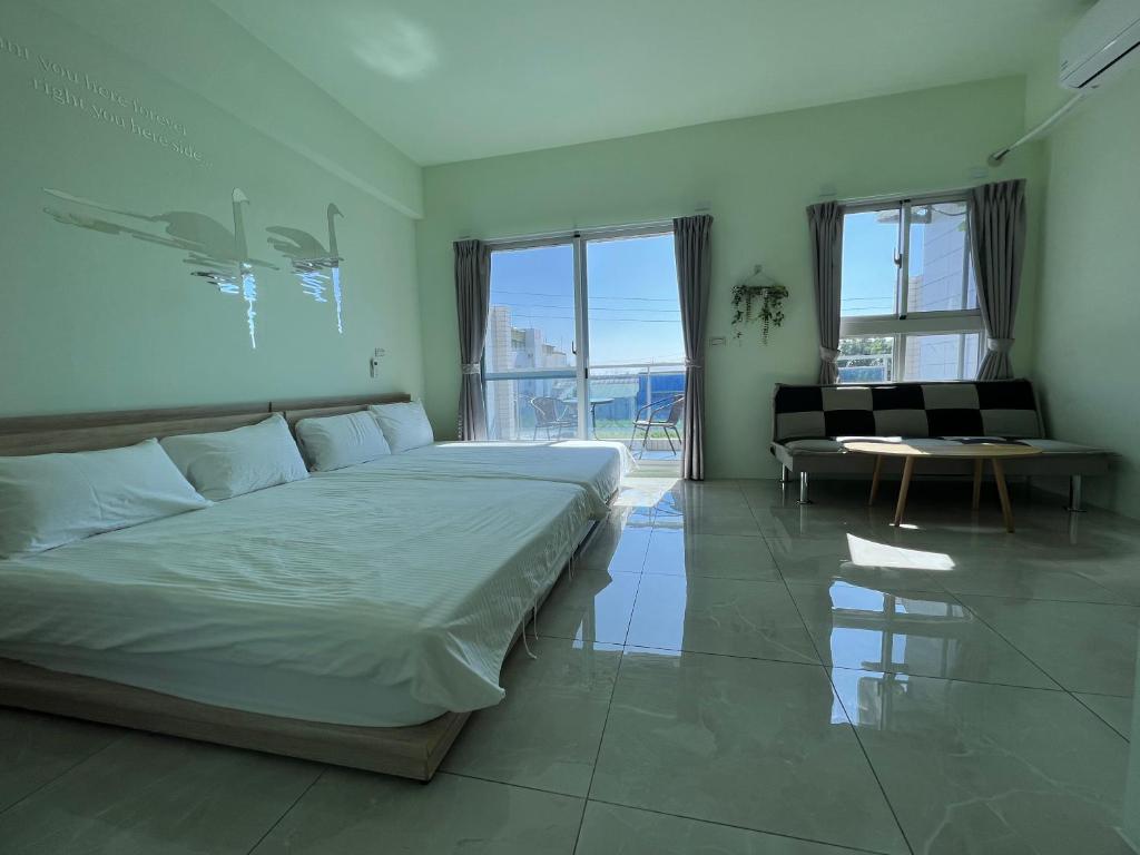 una camera con un grande letto e un soggiorno di Xingda Port Homestay 