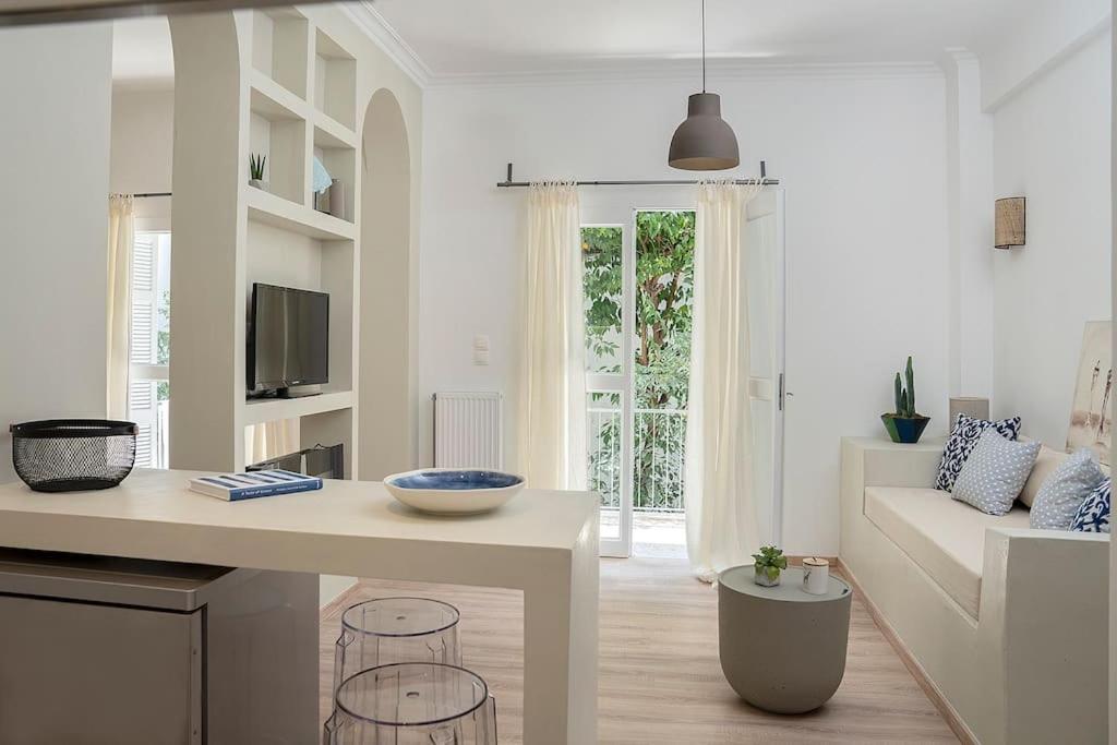een witte woonkamer met een tafel en een bank bij Romantic apartment with hot tub next to Acropolis in Athene
