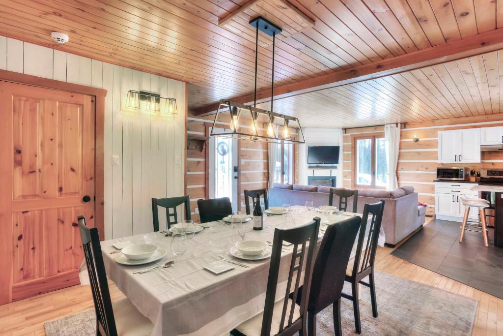 ein Esszimmer mit Tisch und Stühlen und eine Küche in der Unterkunft Hjort cottage - 4 Bedrooms 9 people 2 bathrooms in La Macaza