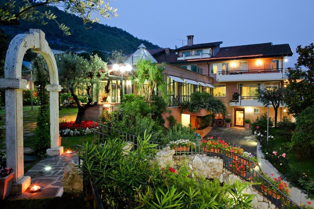 a house with a garden with flowers in front of it at Hotel Des Reves in SantʼElia Fiumerapido