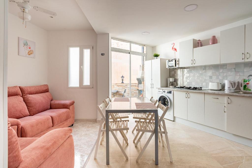 cocina y sala de estar con mesa y sofá en Rooms Breeze & Sun, en Málaga