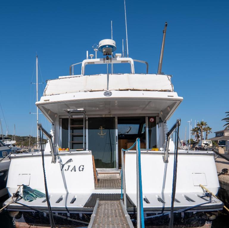 un bateau blanc amarré dans un port de plaisance dans l'établissement HEBERGEMENTS BATEAUX A QUAI, à Porquerolles