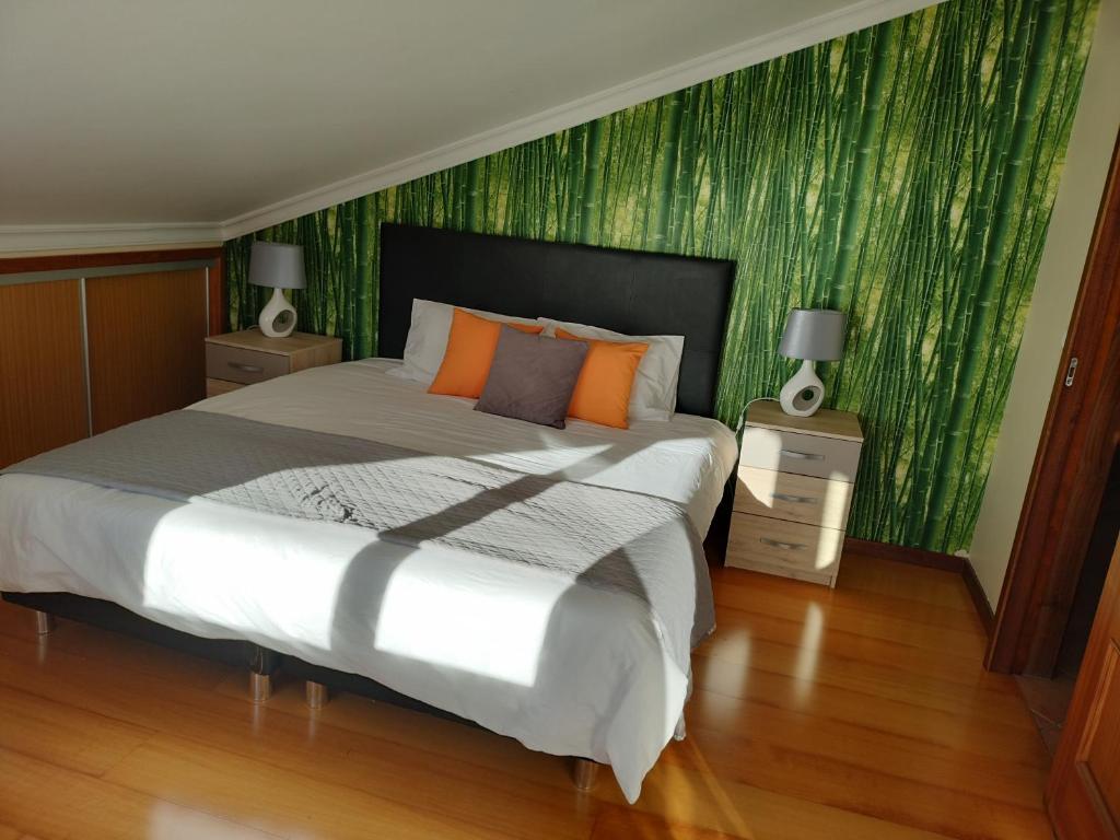 ein Schlafzimmer mit einem großen Bett und einer grünen Tapete in der Unterkunft Beautiful View 2 - Arco da Calheta - Ilha da Madeira in Arco da Calheta