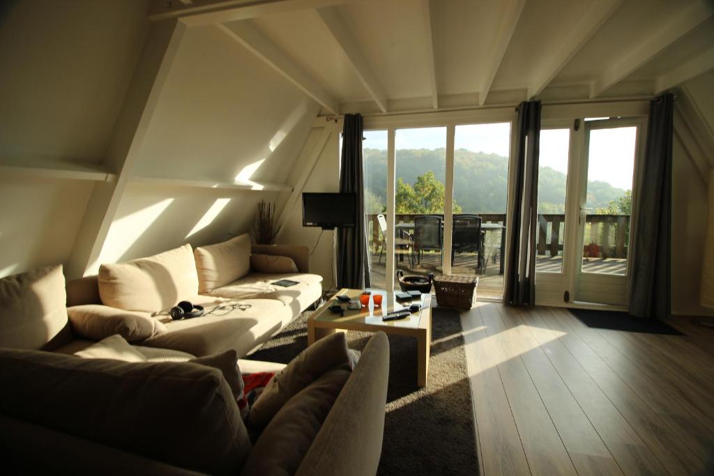 una sala de estar con 2 sofás y una ventana grande en De Oranje Kabouter, en Durbuy