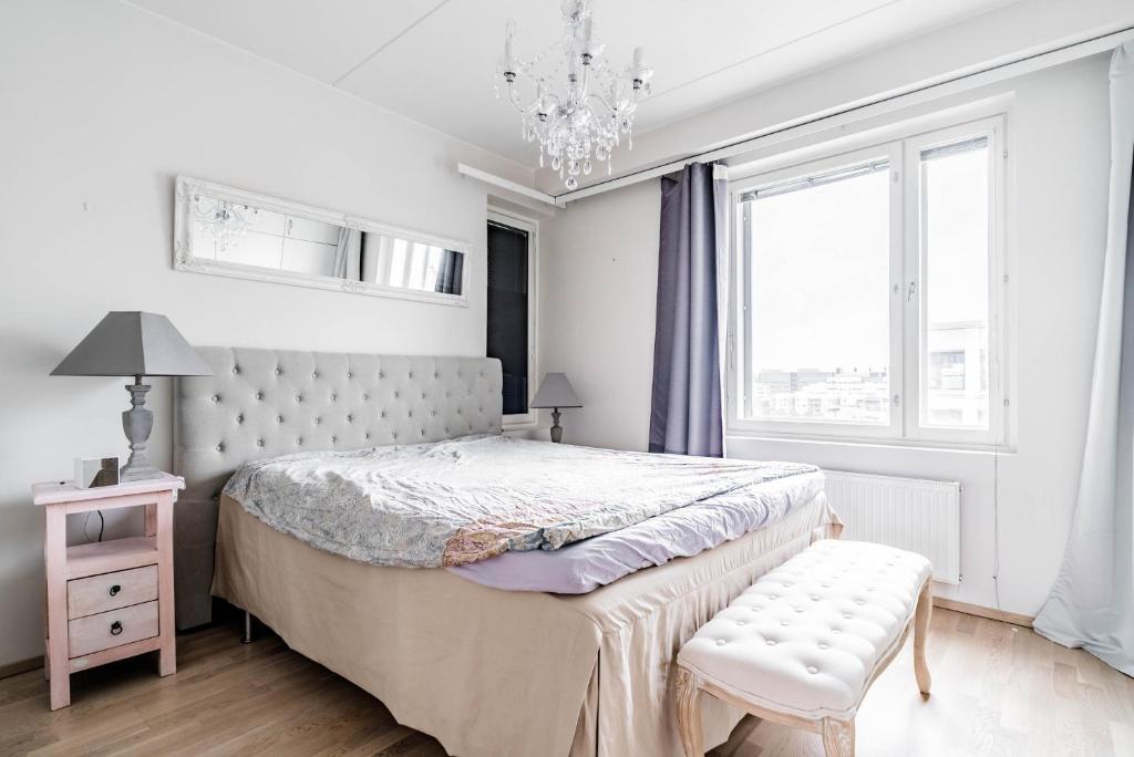 a bedroom with a bed and a chair and a chandelier at Beautiful penthouse in the center of Helsinki in Helsinki