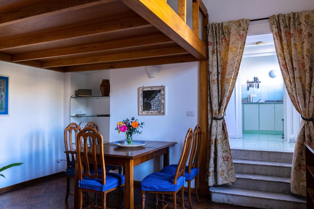 a dining room with a wooden table and chairs at Casa Antica Pizzofalcone in Naples