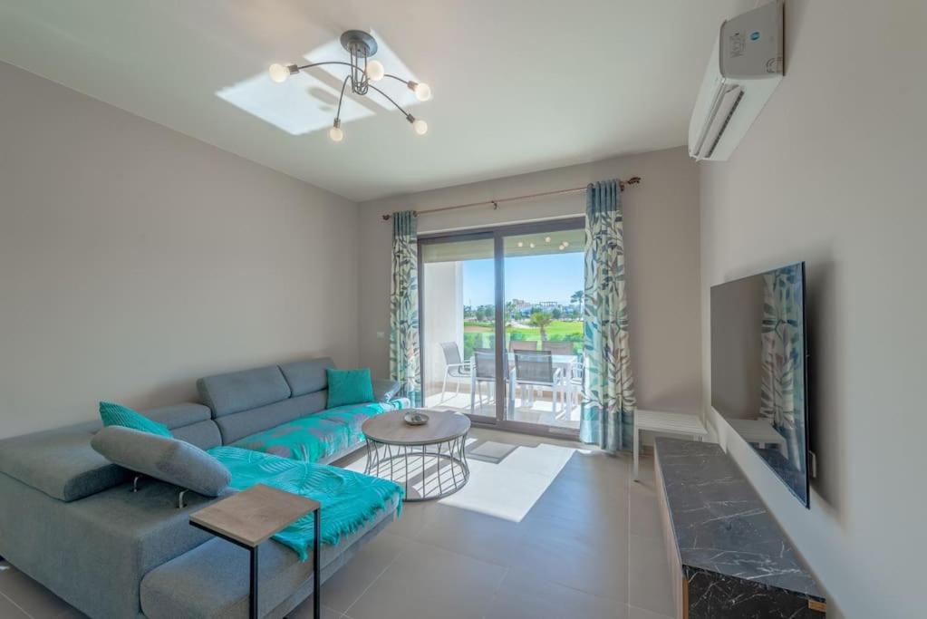 un soggiorno con divano blu e tavolo di New 2-Bedroom, Top Location-Cyan, El Gouna a Hurghada