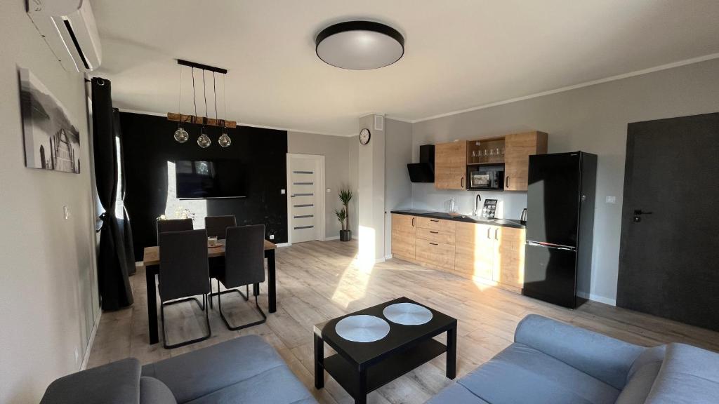 a living room with a couch and a table and a kitchen at Apartamenty Czarna Perła in Kowary