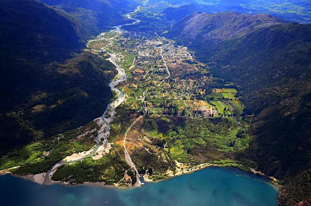 an aerial view of a town on a mountain next to water at Murmullos del bosque in Lago Puelo