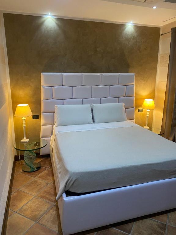 een slaapkamer met een groot wit bed met 2 lampen bij Colle De Siena Rooms in Cassino