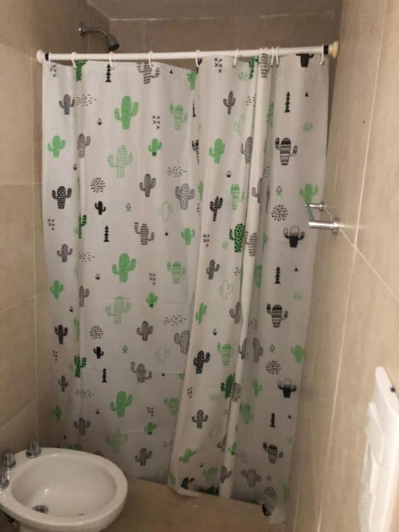 un baño con cortina de ducha con animales. en Coqueto departamento boutique en Mar del Plata