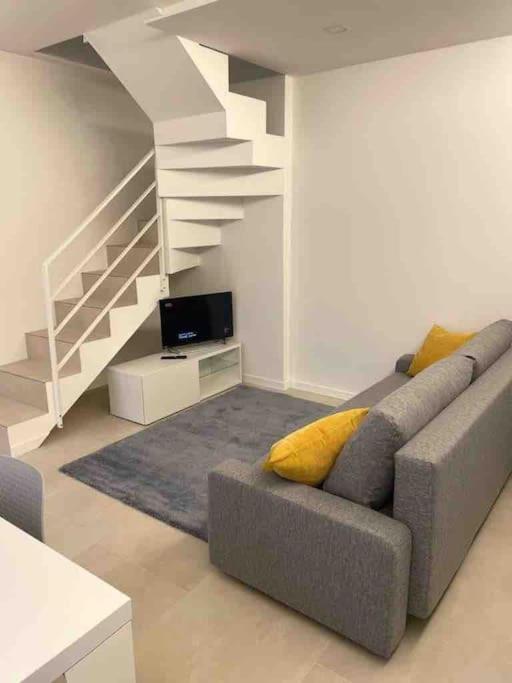 ein Wohnzimmer mit einem Sofa und einer Treppe in der Unterkunft Sweet home... Parking inside in Azzano San Paolo