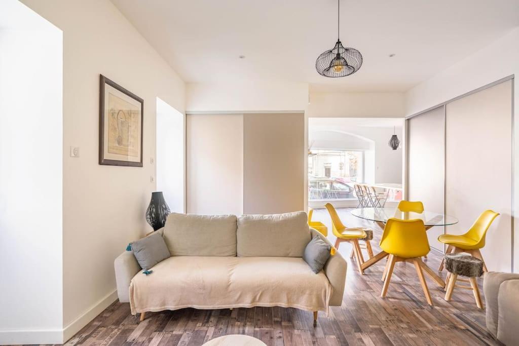 a living room with a couch and yellow chairs at Superbe appartement avec parking gratuit in Lons-le-Saunier