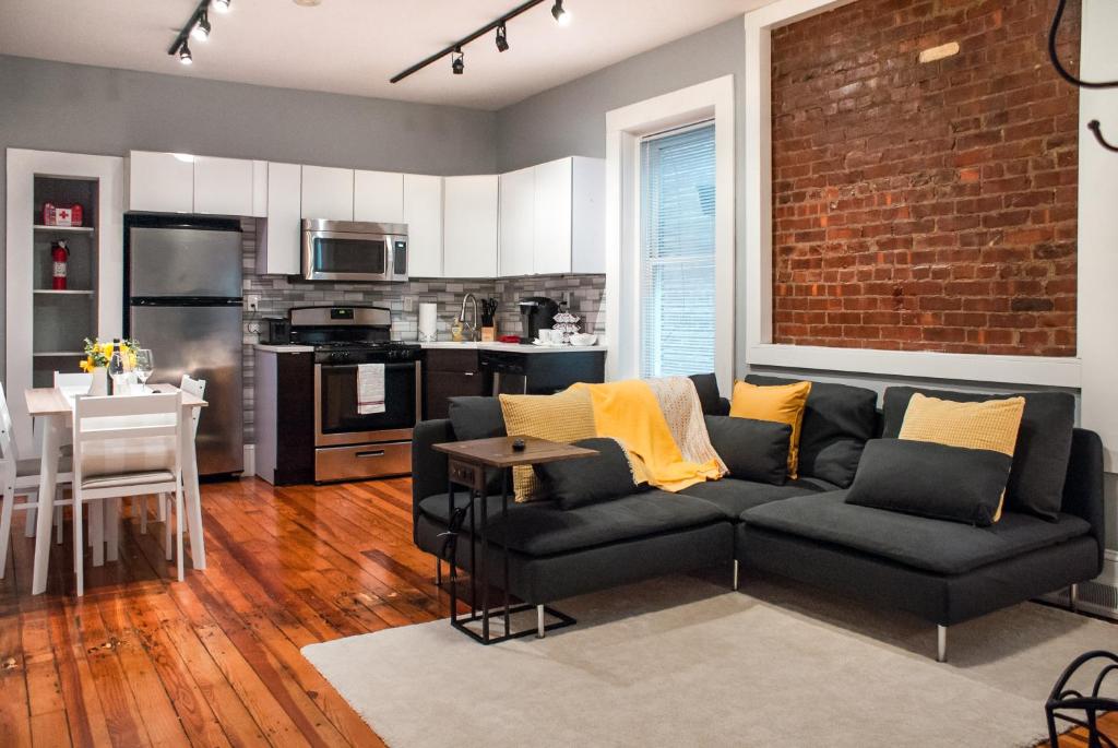 uma sala de estar com um sofá e uma cozinha em Gorgeous 1BR Wooster Sq. apt. - wshr/dryr, parking em New Haven