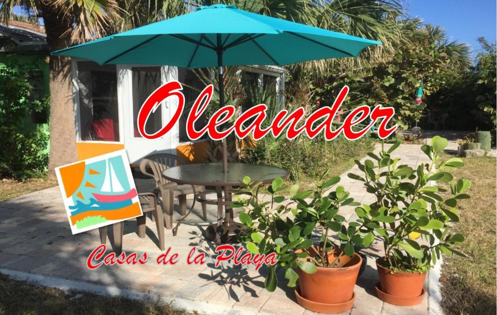 een tafel met een paraplu en een aantal planten bij Oleander Cottage- in the Heart of Flagler Beach and steps to the Beach! in Flagler Beach