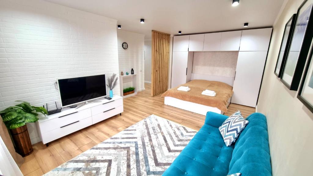 salon z niebieską kanapą i sypialnią w obiekcie Уютные апартаменты w mieście Ałma-Ata
